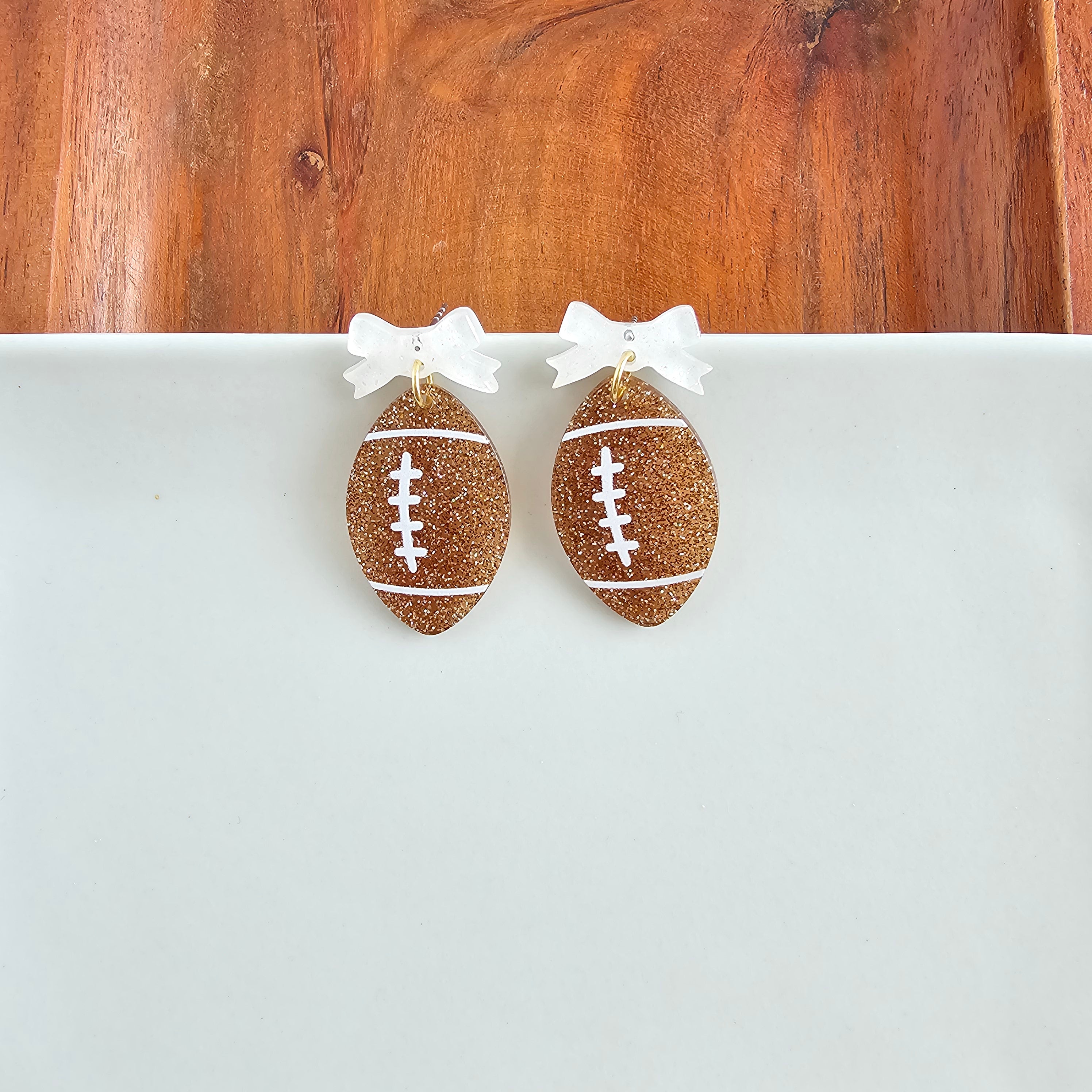 Shop Bow Football Earrings- at Ruby Joy Boutique, a Women's Clothing Store in Pickerington, Ohio