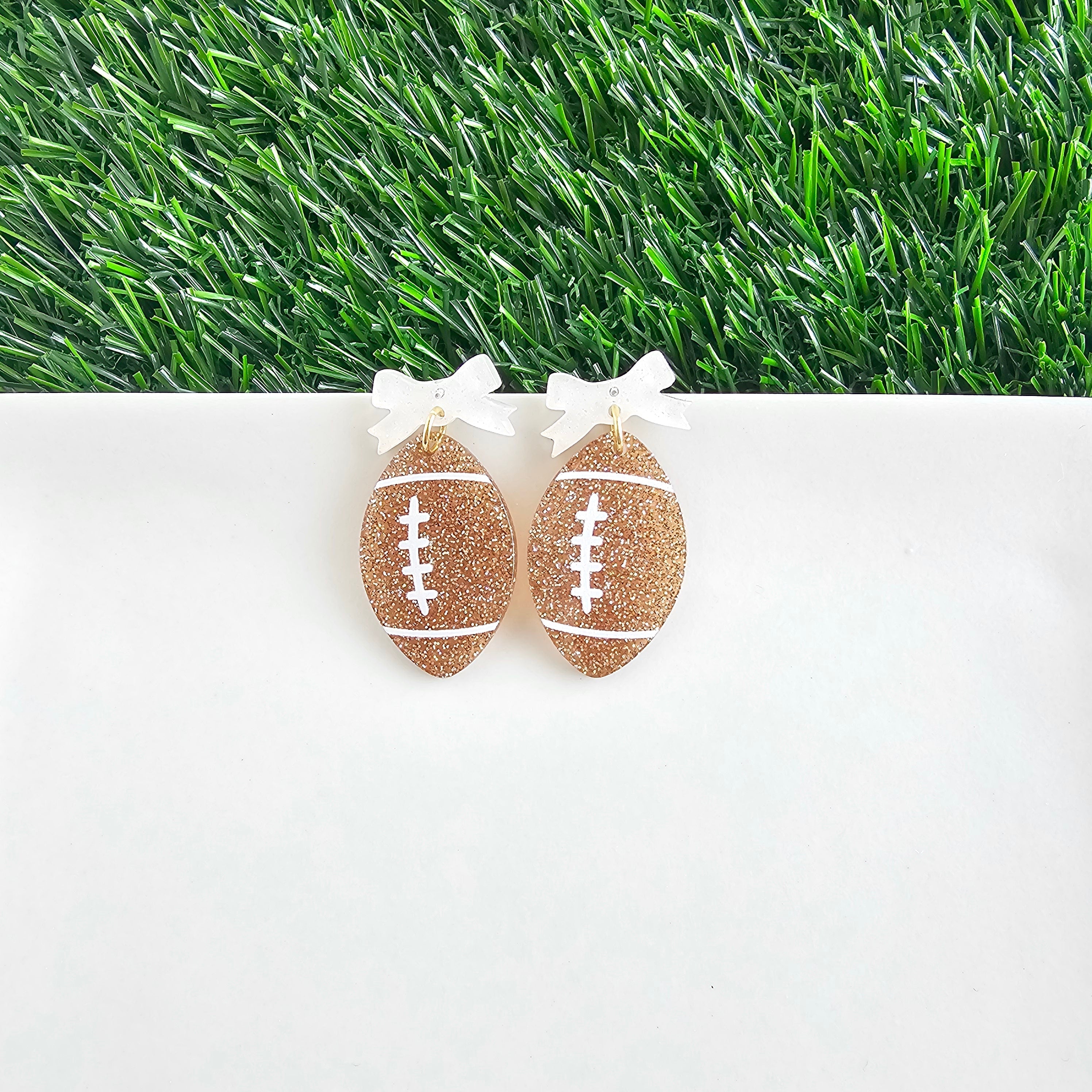 Shop Bow Football Earrings- at Ruby Joy Boutique, a Women's Clothing Store in Pickerington, Ohio