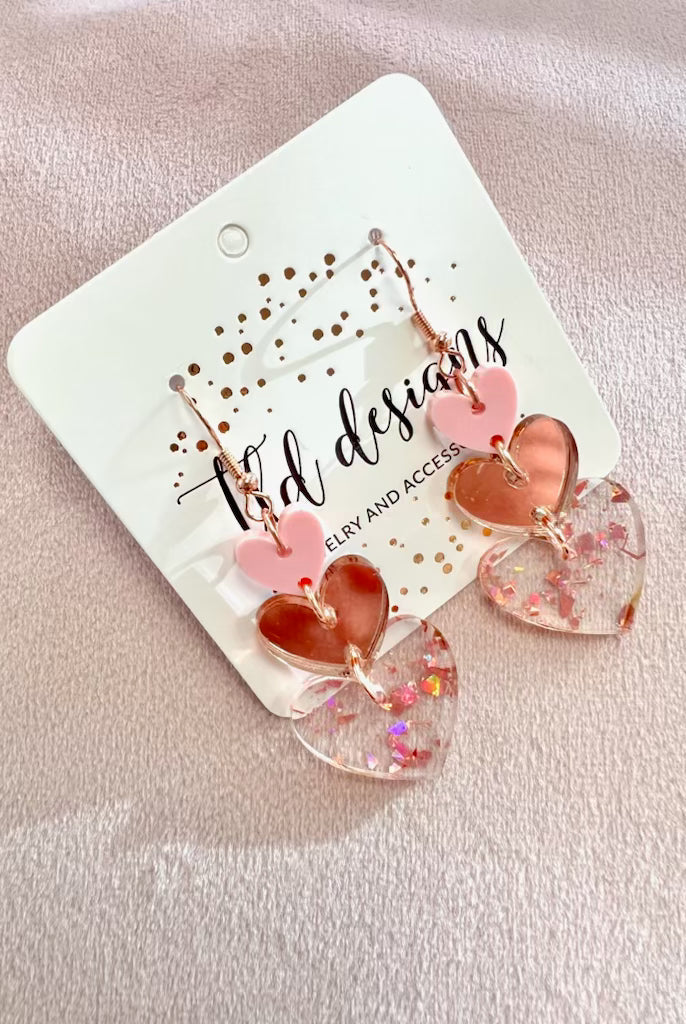 Shop Rosy Triple Heart Dangle Earrings- at Ruby Joy Boutique, a Women's Clothing Store in Pickerington, Ohio
