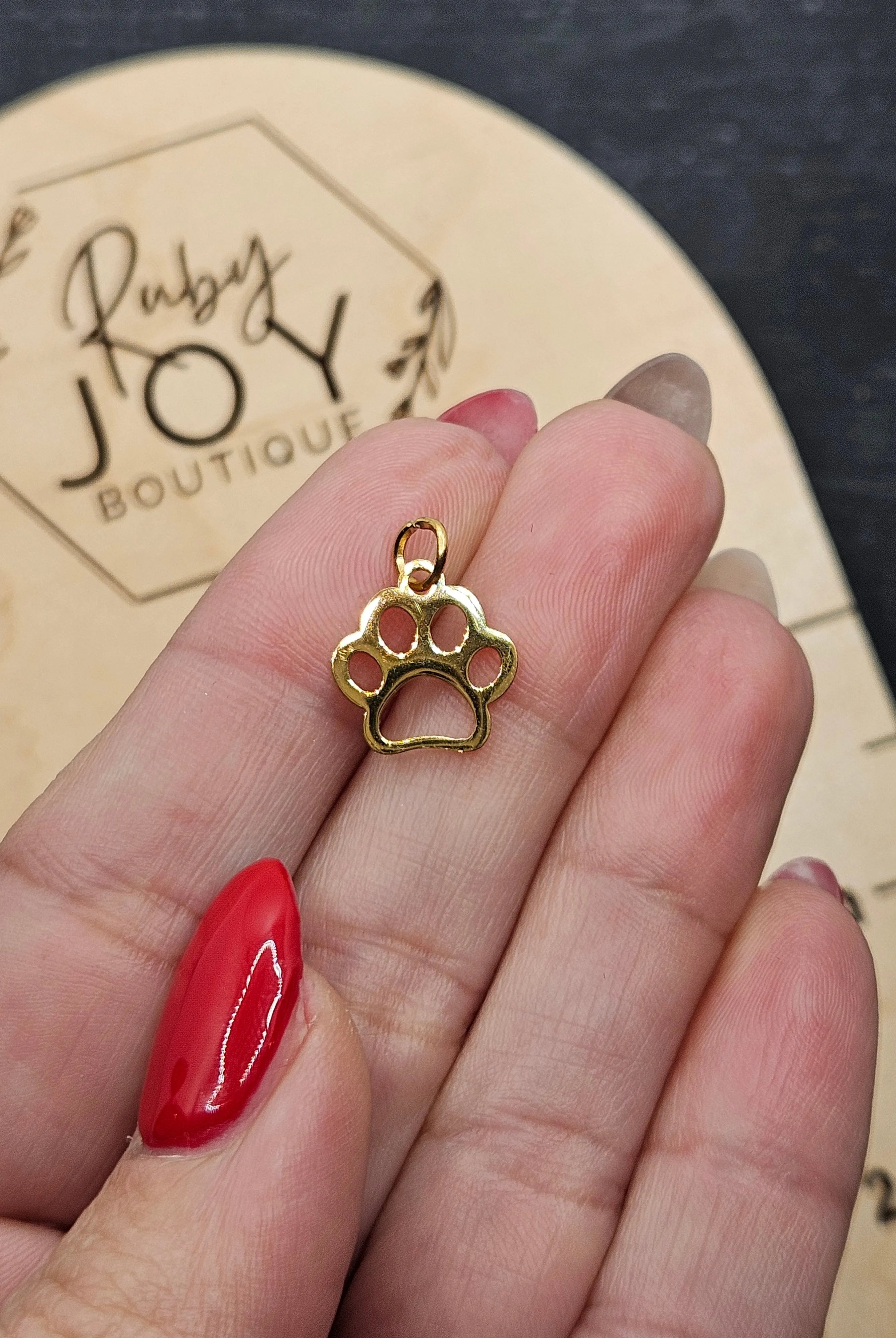 Shop Paw Print Outline Charm- at Ruby Joy Boutique, a Women's Clothing Store in Pickerington, Ohio