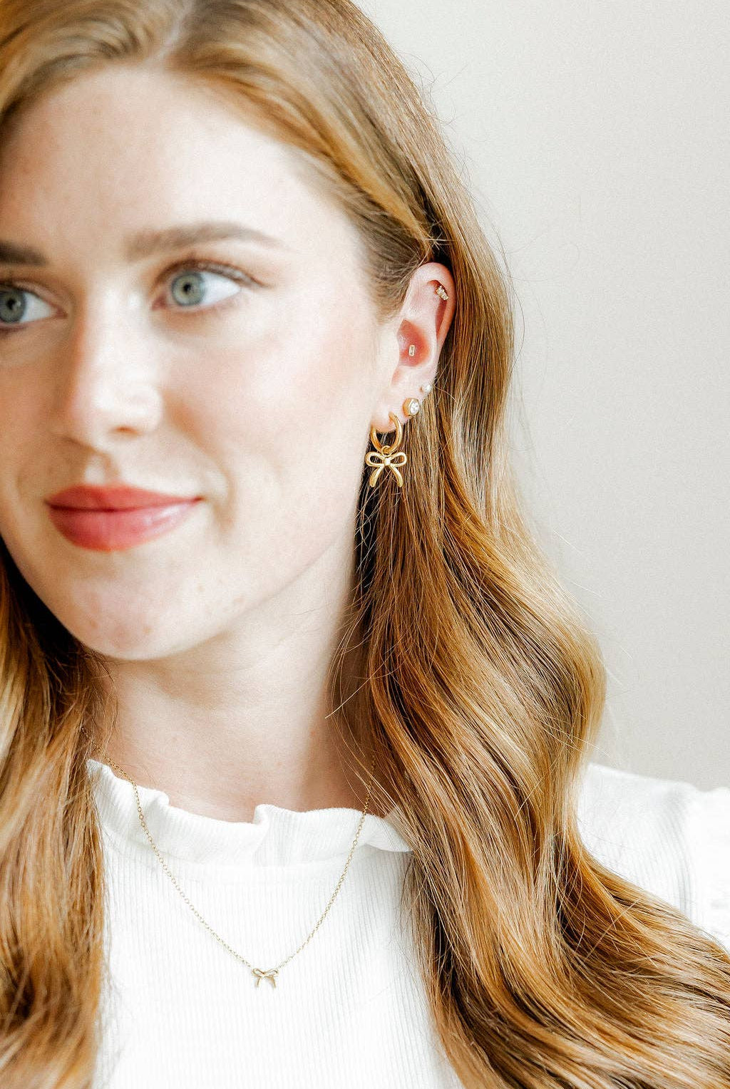 Shop Sadie Bow Huggie Charm Earrings - Gold- at Ruby Joy Boutique, a Women's Clothing Store in Pickerington, Ohio