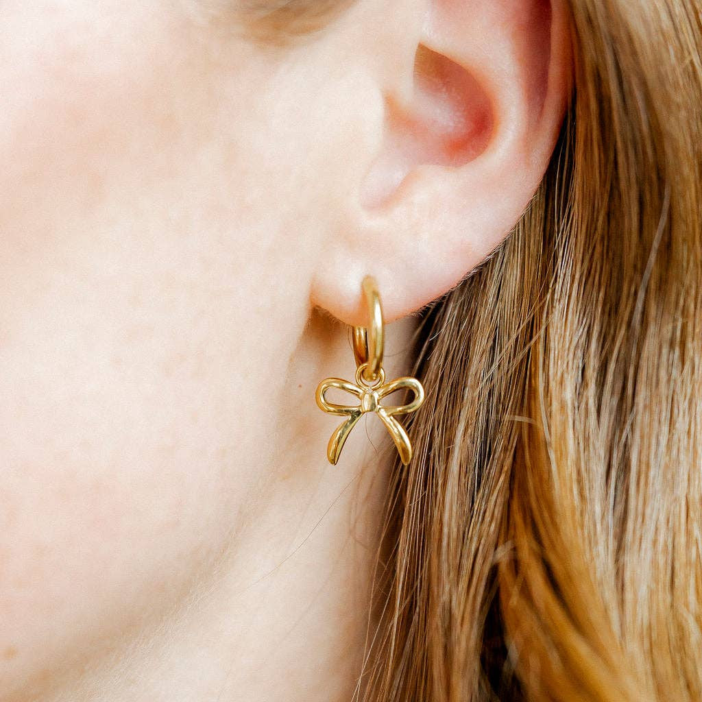 Shop Sadie Bow Huggie Charm Earrings - Gold- at Ruby Joy Boutique, a Women's Clothing Store in Pickerington, Ohio