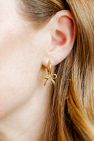 Shop Sadie Bow Huggie Charm Earrings - Gold- at Ruby Joy Boutique, a Women's Clothing Store in Pickerington, Ohio