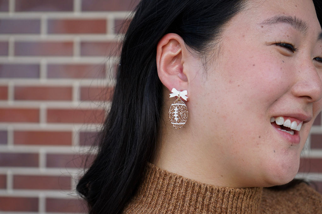 Shop Bow Football Earrings- at Ruby Joy Boutique, a Women's Clothing Store in Pickerington, Ohio