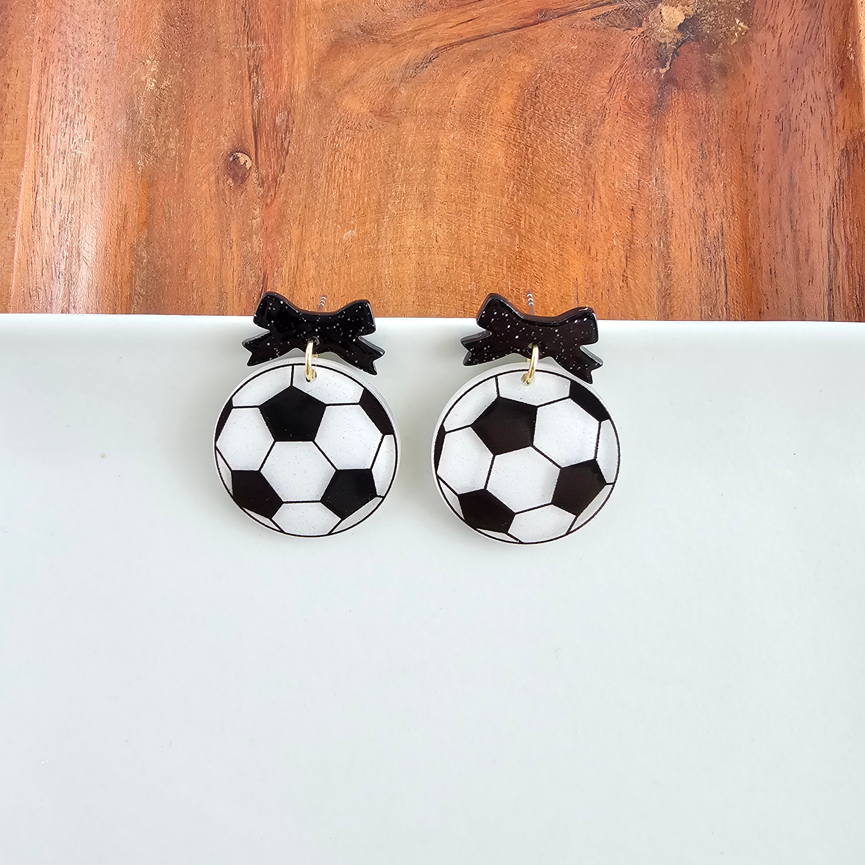 Shop Bow Soccer Ball Earrings- at Ruby Joy Boutique, a Women's Clothing Store in Pickerington, Ohio