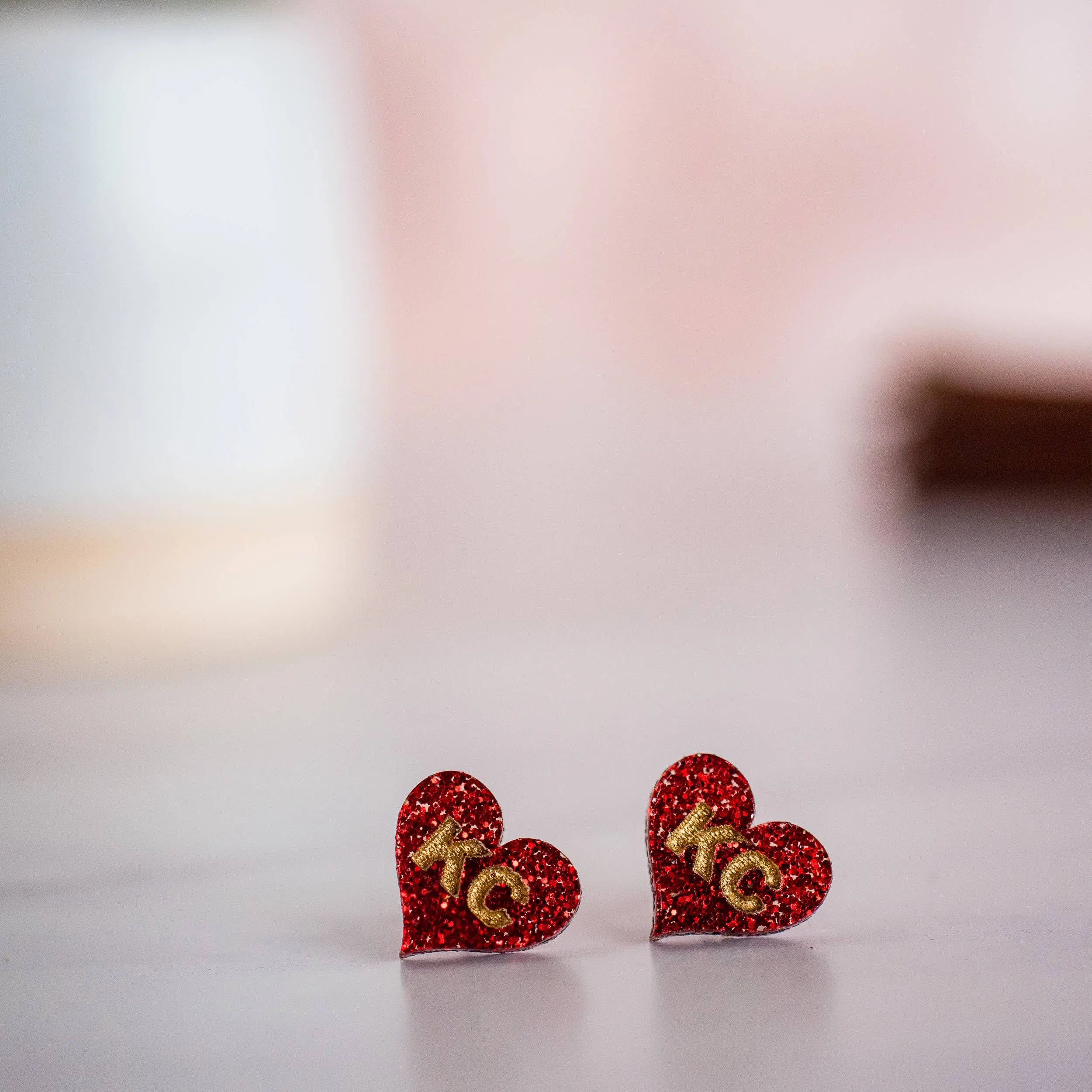 Shop Kansas City Chiefs Football Hand Painted Red Glitter KC Heart Studs-Earrings at Ruby Joy Boutique, a Women's Clothing Store in Pickerington, Ohio