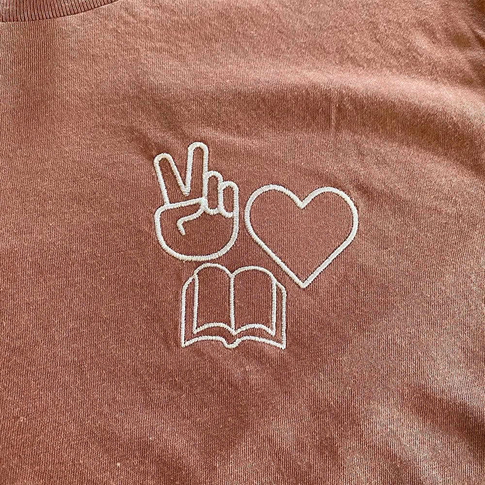 Shop Peace, Love, Books Classic Tee | Kind Cotton- at Ruby Joy Boutique, a Women's Clothing Store in Pickerington, Ohio
